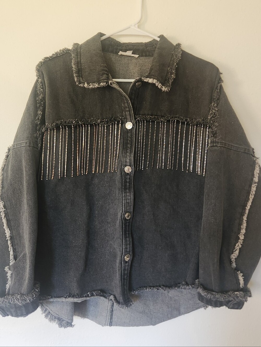 Women's Black Distressed Denim Jacket with Rhinestone Fringe.